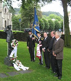 I tråd med tradisjonen la korpsgytter og gamlekarer ned krans og blomster på statuen Sandviksgutten etter seremonien i kirken