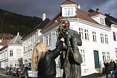 Irmelin Flygansvær (leder for Damegarden) legger blomster på Madam Felle. Foto: Mona Lygre