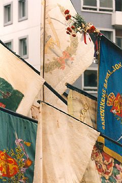 En kollasj av de gamle fanene. Med klokken: 1859 (Ørnefanen), 1977, 1902, 1865 (Fi'll), 1927 og 1890 (Håvaren). Nesten skjult i midten: 1891.