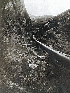 Rørgaten i Munkebotn. I dag er bare støttene igjen nedenfor demningen. Foto H. Nic. Meyer. Gamle Bergen billedsamling.